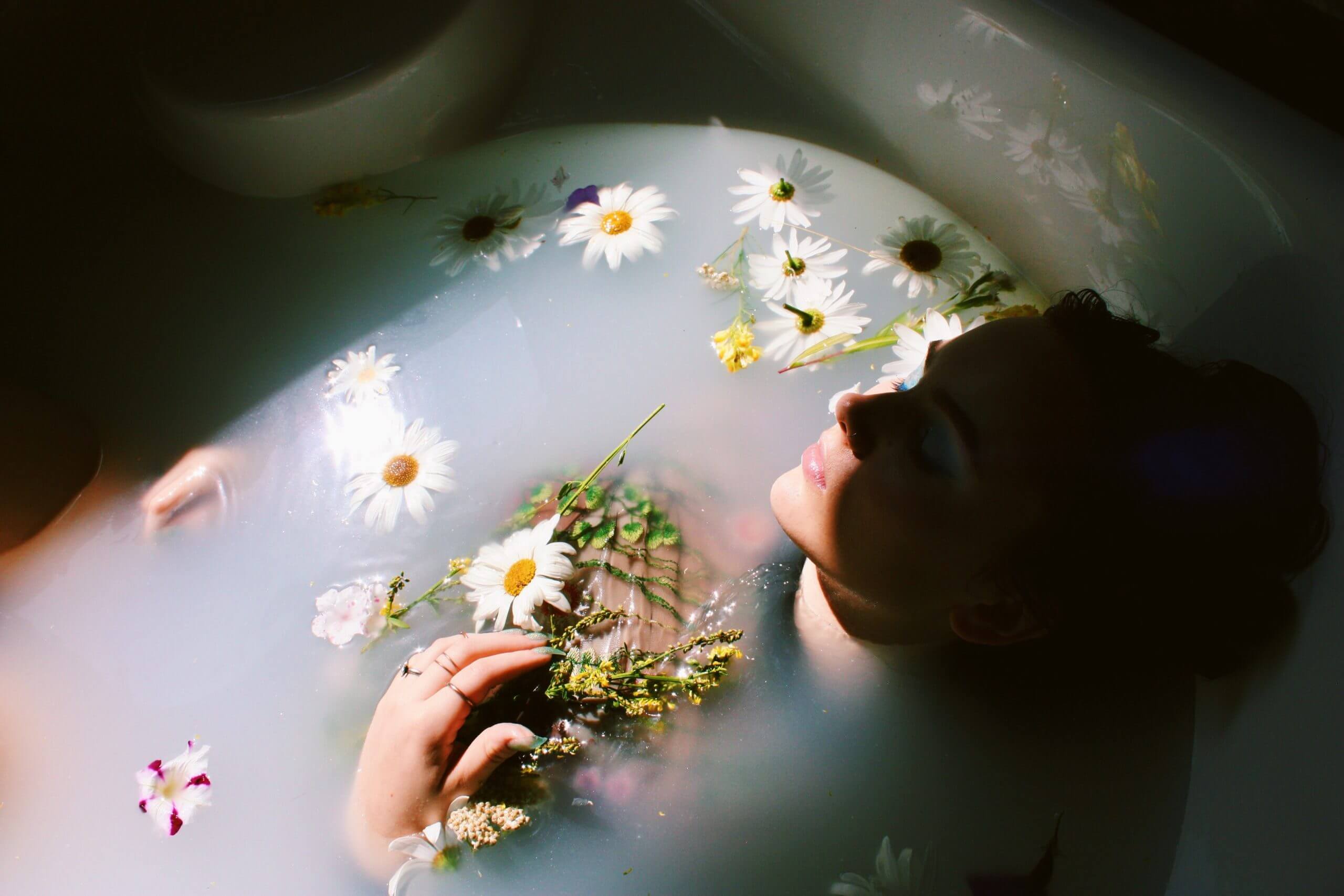 photo d'une femme dans un bain rempli de fleurs